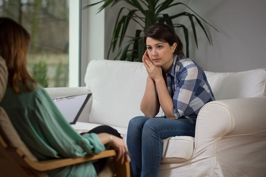 Young woman talking with psychologist